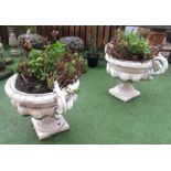 Large pair of cast iron urns, with ornate floral handles and scroll rims, on square bases, (2)