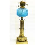 Early C20th brass oil lamp, leaf cast column on square base with blue reservoir clear chimney and