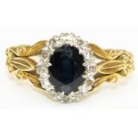 18ct yellow gold, sapphire and diamond cluster ring, the central oval cut sapphire surrounded by a