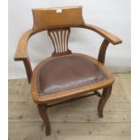 Early 20th century golden oak desk chair, raised back with pierced vase shaped splat, studded rexine