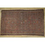 C20th Caucasian style patterned rug, brick red ground with central geometric field, repeating