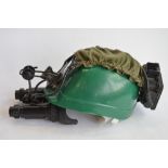 A set of night vision goggles with battery pack attached to a plastic miners hat. Takes 1 "C" type