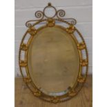 Gilt framed oval mirror with bevelled edge and floral design, 47cm x 30cm