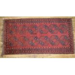 C20th Bukhara red ground rug, with twelve octagonal medallions and stylised geometric border,