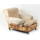 Property of a lady - a Victorian upholstered deep seated armchair, with turned front legs & castors.