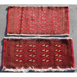 Two similar Turkoman woollen hand-made mats with red grounds, the larger 43 by 19ins. (110 by