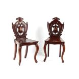 Property of a deceased estate - a pair of Victorian carved mahogany hall chairs, each with