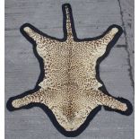 Property of a lady - a Cheetah skin rug, early / mid 20th century, with black felt backing,