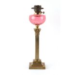 Property of a lady - a late Victorian brass Corinthian column oil lamp with cranberry glass