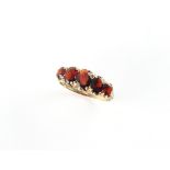 A 9ct gold garnet five stone ring, with five graduated oval cushion cut garnets, size O.