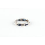 Property of a lady - an unmarked platinum sapphire & diamond eternity ring, set with pairs of square