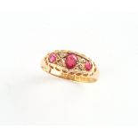 An early 20th century 18ct yellow gold ruby & diamond ring, the three oval cushion cut rubies