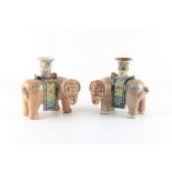 Two similar Chinese famille rose candlesticks or candle holders modelled as caparisoned elephants,