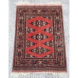 Property of a gentleman - a Belouch rug, with red ground, 59 by 41ins. (150 by 104cms.).