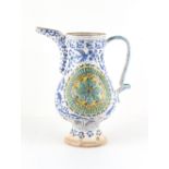 A Turkish Ottoman Kutahya pottery jug, painted in blue with scrolling foliage around a moulded