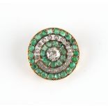 An unmarked yellow gold emerald & diamond target pendant brooch, the round cut emeralds weighing