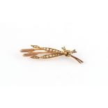 An unmarked yellow gold (tests 9ct) tied wheat brooch, 54mm long, approximately 6.0 grams.