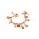 Property of a deceased estate - a 9ct gold charm bracelet with ten charms, eight full hallmarked,