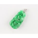 An unusually large Chinese carved jadeite bolder pendant depicting fish, the apple green stone