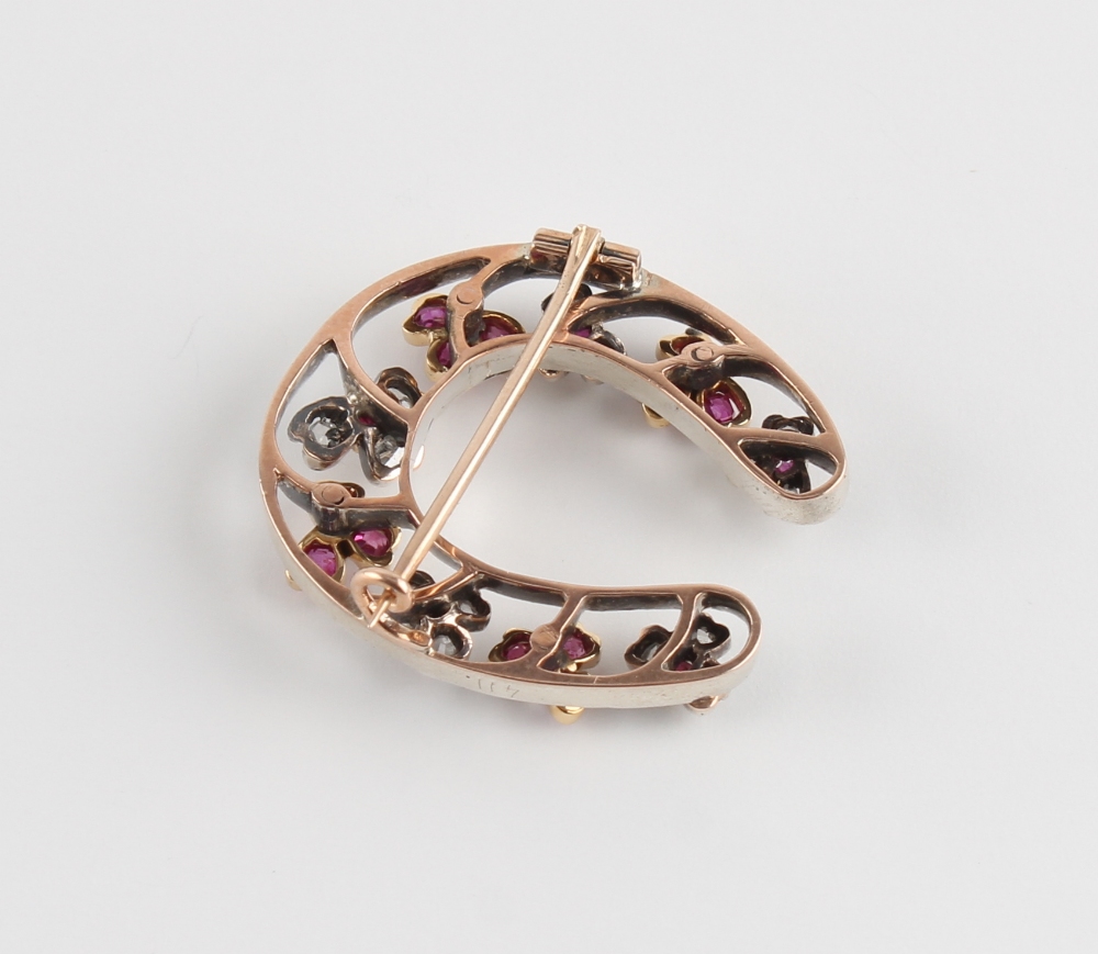 A Victorian unmarked rose gold ruby & diamond horseshoe brooch, 30mm long. - Image 3 of 3