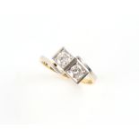 An 18ct yellow gold & platinum diamond two stone square set crossover ring, the round brilliant