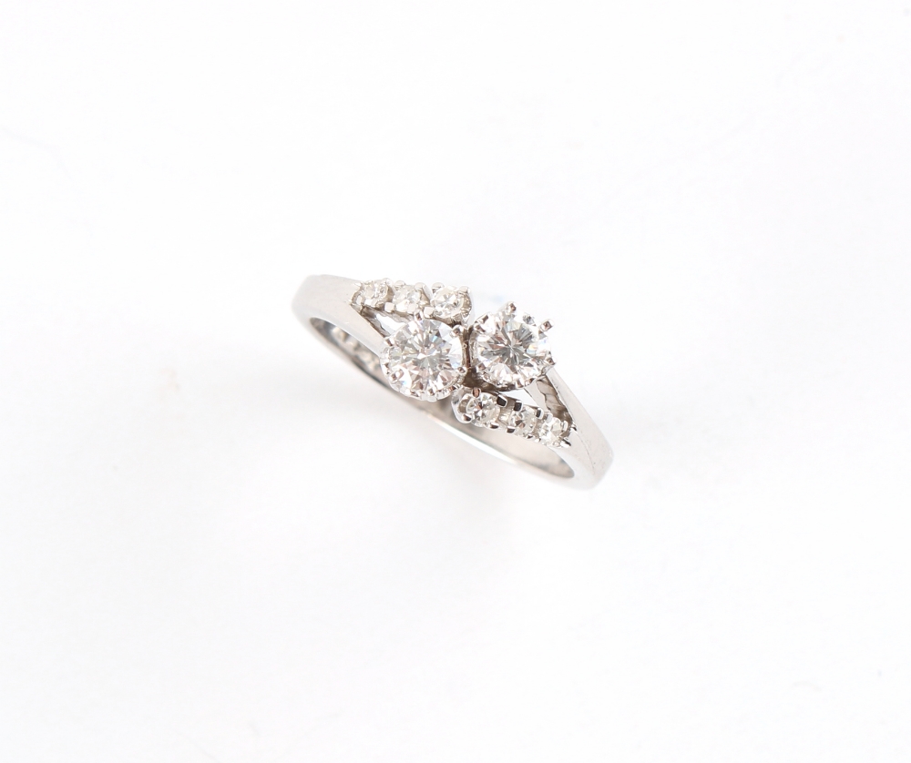 A 14ct white gold diamond crossover ring, with diamond shoulders, the two larger round brilliant cut