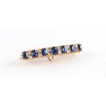 An unmarked yellow gold sapphire & diamond slightly arched rectangular brooch, with folding loop