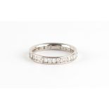 An unmarked white gold diamond eternity ring, set with round brilliant cut diamonds alternating with