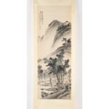 A Chinese scroll painting on paper depicting figures in a mountainous river landscape, signed with