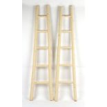 Property of a gentleman - a pair of cream painted bamboo ladders, of tapering form, 87 and 86ins. (