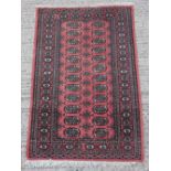 Property of a lady - a Pakistan Bokhara design hand knotted wool rug, with salmon ground, 62 by