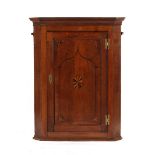 Property of a gentleman - a George III oak & parquetry inlaid corner wall cupboard, enclosing shaped
