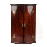 Property of a gentleman - a mid 18th century George II/III mahogany bow-fronted two-door corner wall