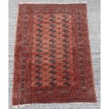 Property of a lady - a hand knotted wool Tekke Bokhara design rug, with rust coloured ground, 74