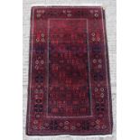 Property of a lady - an Afghan rug with dark red ground, 60 by 33ins. (152 by 84cms.).