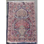A Kerman woollen hand-made rug with blue ground, 59 by 37ins. (150 by 94cms.).