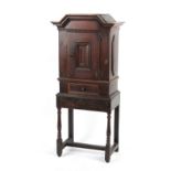 Property of a lady - a small oak cabinet on stand, elements 18th century, with fielded panels, 23.