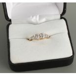 An Edwardian 18ct yellow gold diamond two stone ring, the pierced setting with millegrain diamond
