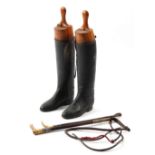 Property of a lady - a pair of black leather riding boots with wooden trees; together with two whips