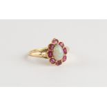 An unmarked yellow gold opal & ruby ring, the pear shaped opal set within a pear shaped floral