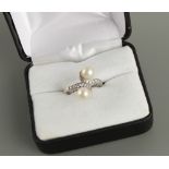 An unmarked platinum natural saltwater pearl & diamond crossover ring, the two certificated