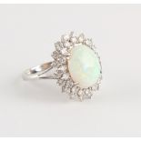 Property of a lady - an 18ct white gold opal & diamond oval cluster ring, the opal measuring