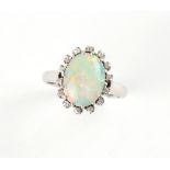 Property of a lady - a platinum or white gold opal & diamond oval cluster ring, the opal measuring