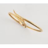An unmarked 18ct yellow gold (tested) ruby & diamond snake torc bangle, approximately 10.8 grams.