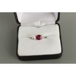 A platinum ruby & diamond three stone ring, the cushion cut ruby weighing approximately 1.39 carats,