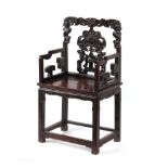 A late 19th century Chinese carved hongmu armchair, with faded old paper label to underside of
