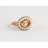 An unmarked 19th century gold topaz & seed pearl ring, the oval cut topaz weighing approximately 1.