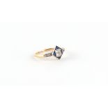 An Art Deco yellow unmarked gold sapphire & diamond ring, the diamond shaped millegrain setting with