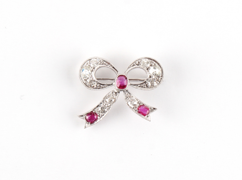 An early 20th century Belle Epoque ruby & diamond ribbon brooch, the three oval cut rubies