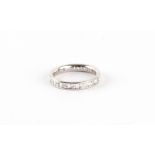 An unmarked white gold diamond eternity ring, set with round brilliant cut diamonds alternating with